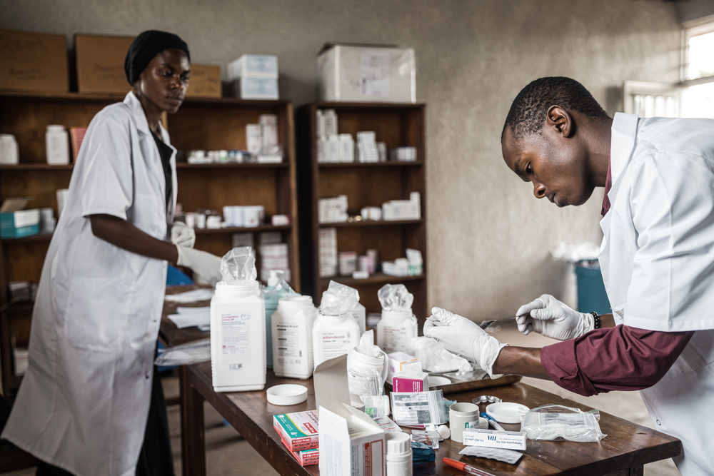 MSF staff handling medicine distribution to displaced people after their consultation at the Rusayo camp.