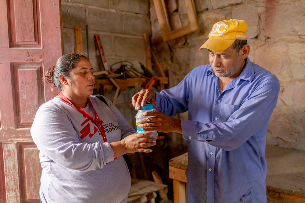 MSF team member distributing jars containing adult mosquitoes with Wolbachia in Tegucigalpa.